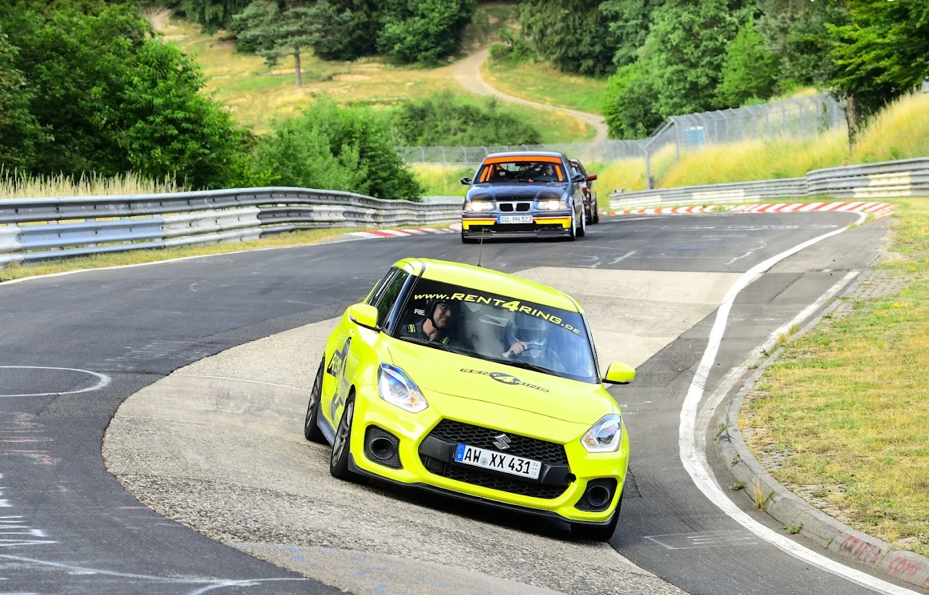 Hyrbil i full fart genom en kurva på Nordschleife, BMW E36 bakom